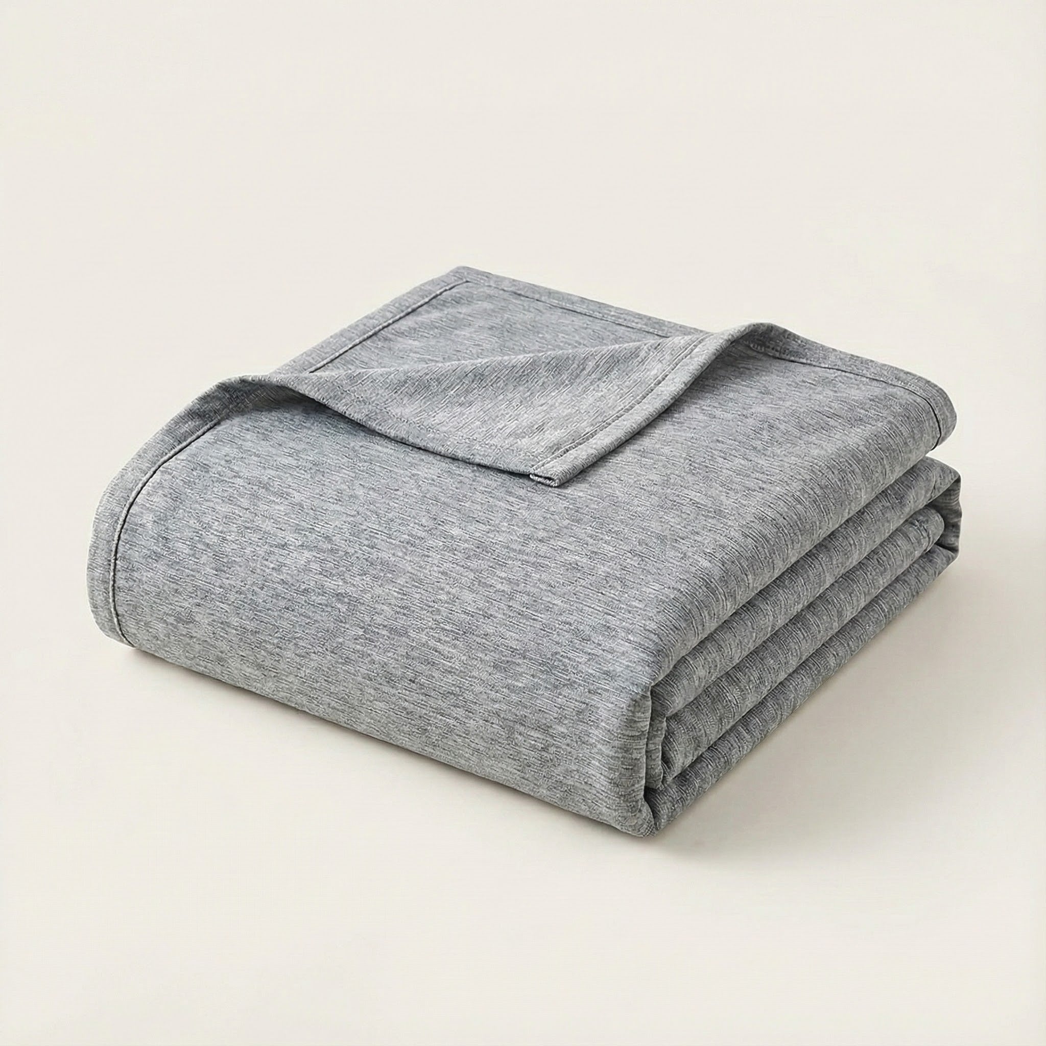 Folded gray blanket on a light beige background