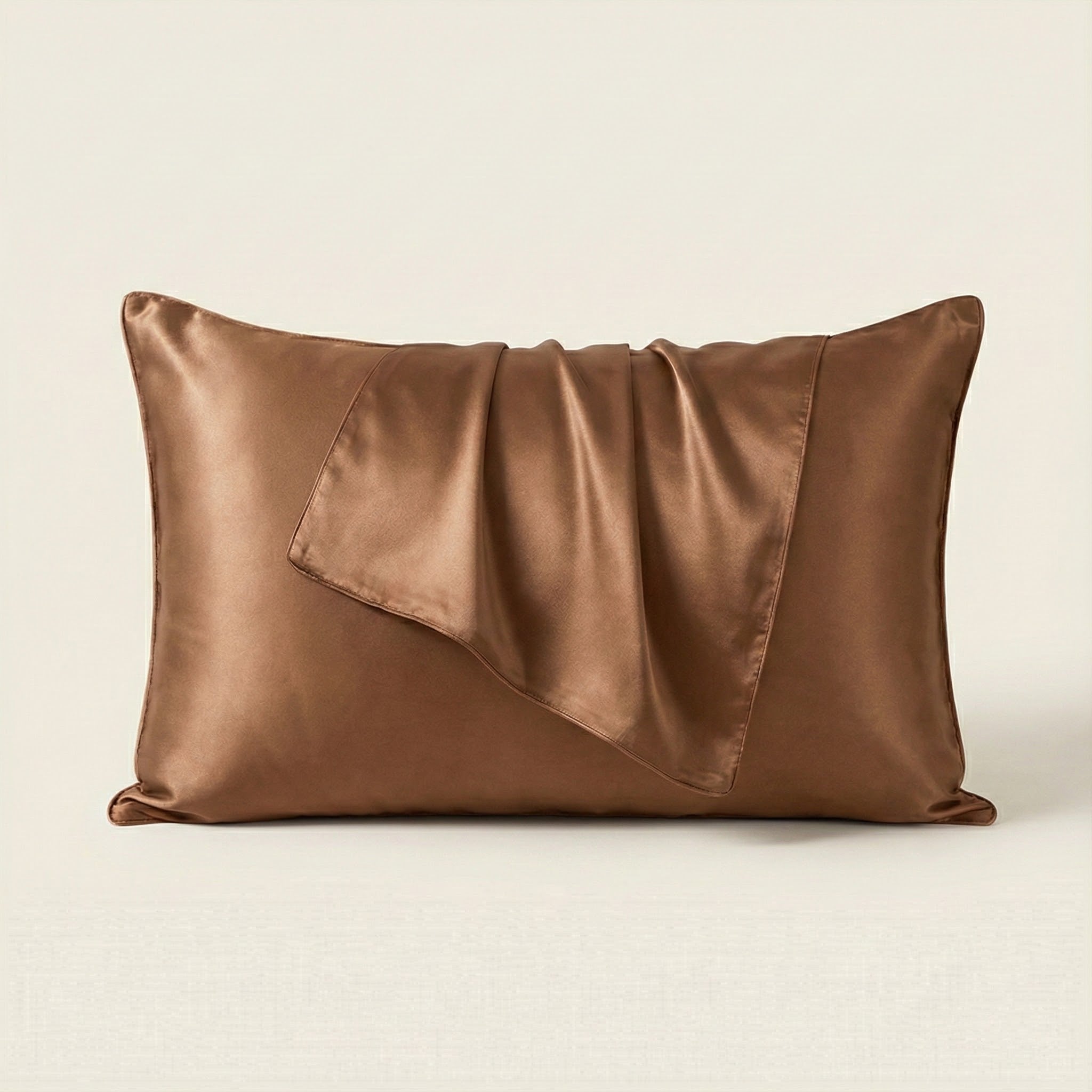 Brown satin pillow on a beige background