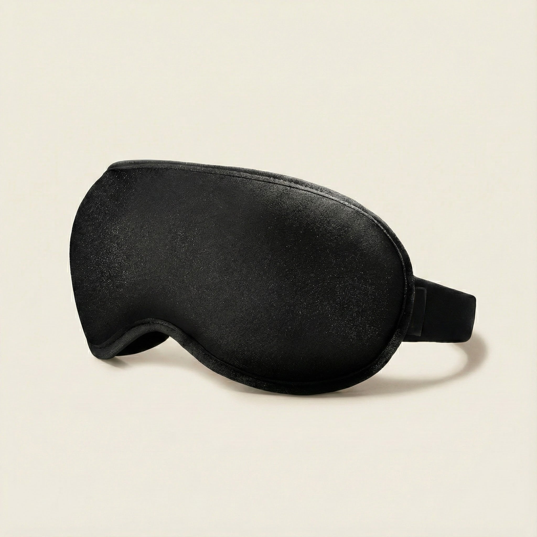 Black sleep mask on a beige background