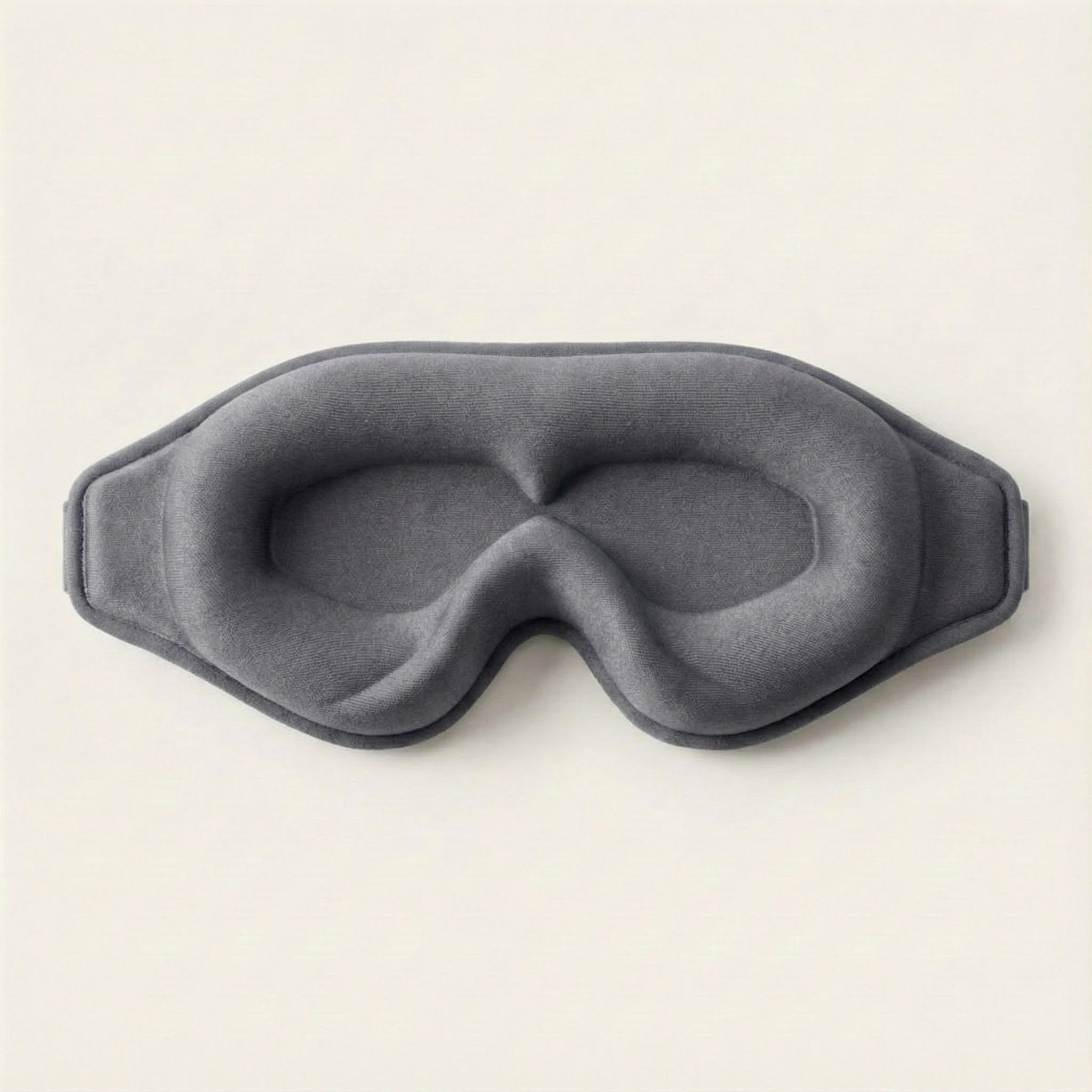 Gray eye mask on a light beige background