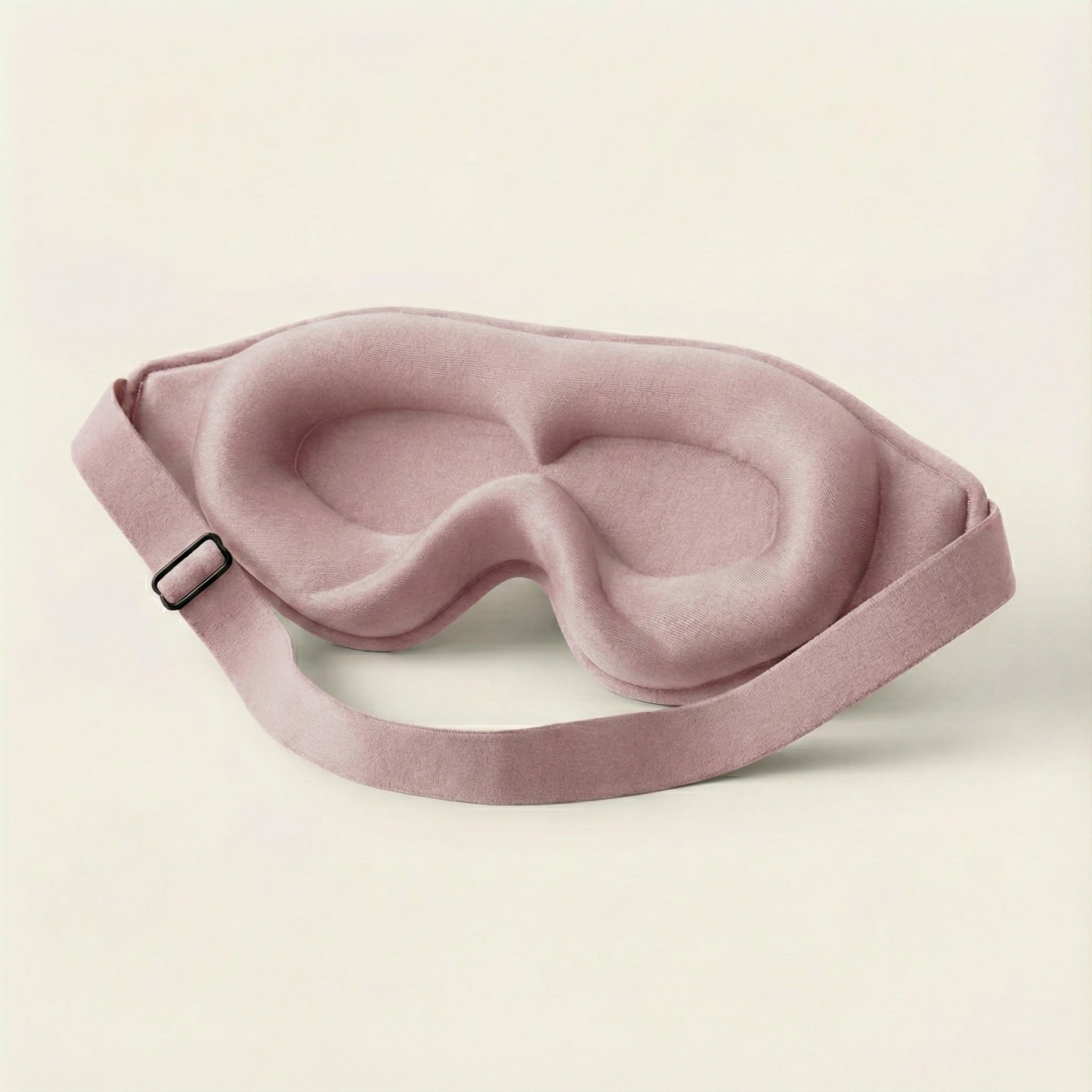 Pink sleep mask on a beige background