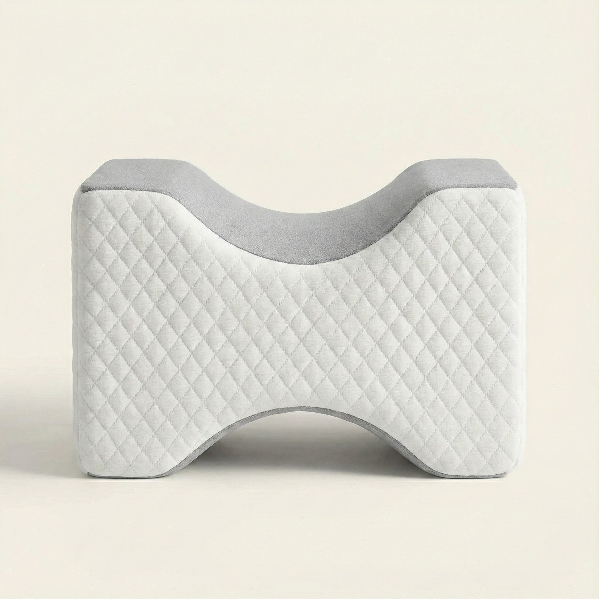 Gray and white quilted pillow on a beige background